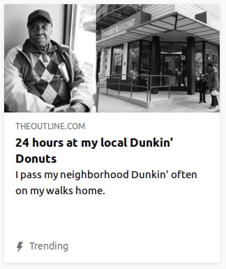 By The Outline. Grayscale photo o’ a guy in diamond-checkered sweater standing gainst a wall with a donut shop ’hind said wall. “I pass my neighborhood Dunkin’ often on my walks home.”